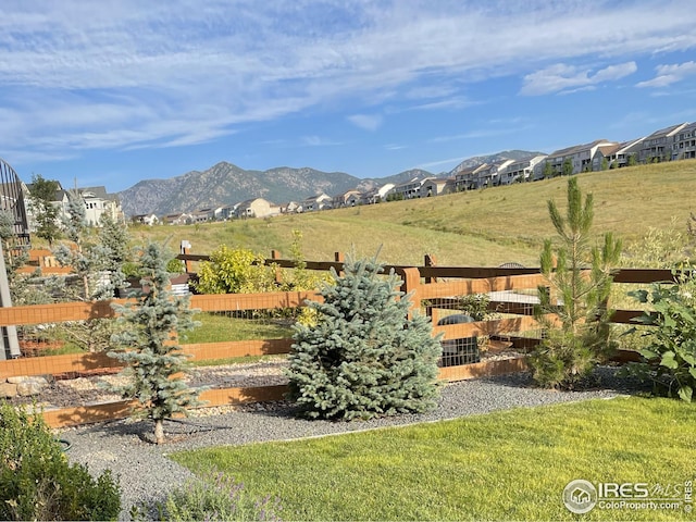 view of yard featuring fence and a mountain view