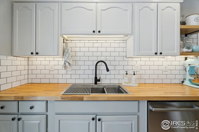 kitchen featuring a sink, wood counters, white cabinets, dishwasher, and open shelves