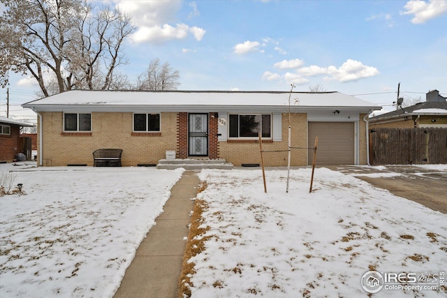 ranch-style home featuring a garage, brick siding, and fence