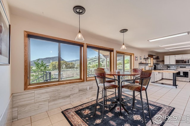 dining space with a mountain view and light tile patterned flooring