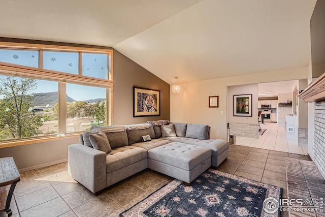 tiled living area with baseboards, a mountain view, and vaulted ceiling