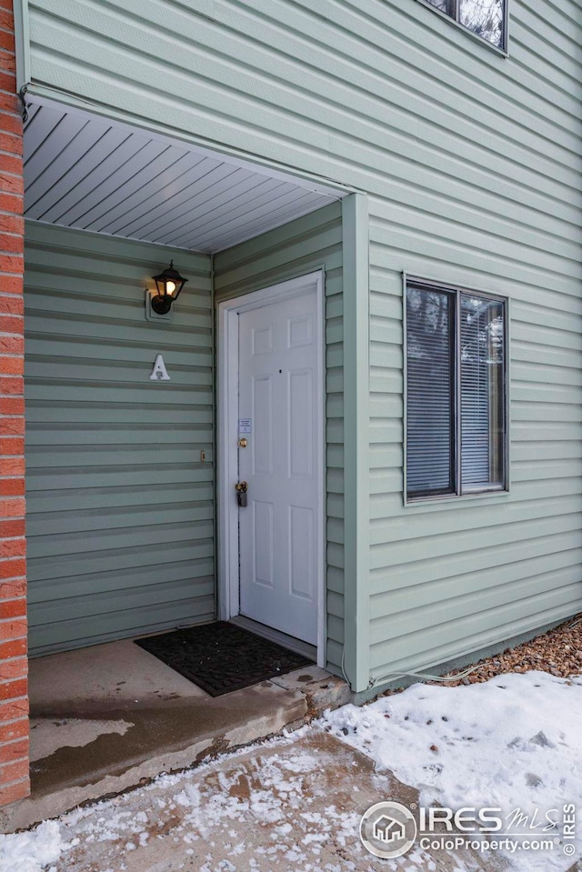 view of snow covered property entrance