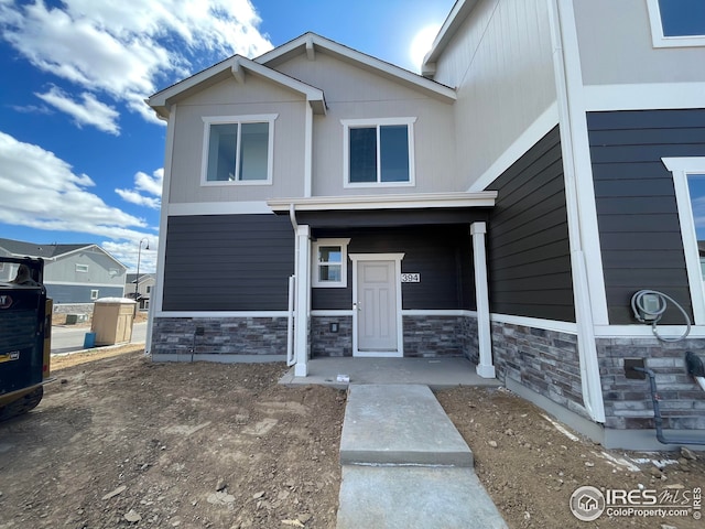 exterior space featuring stone siding and a porch