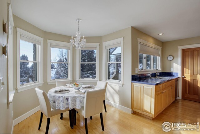 8400 Middle Fork Rd, Boulder, CO 80302 - dining space featuring baseboards, a chandelier, light wood-style flooring, and a healthy amount of sunlight