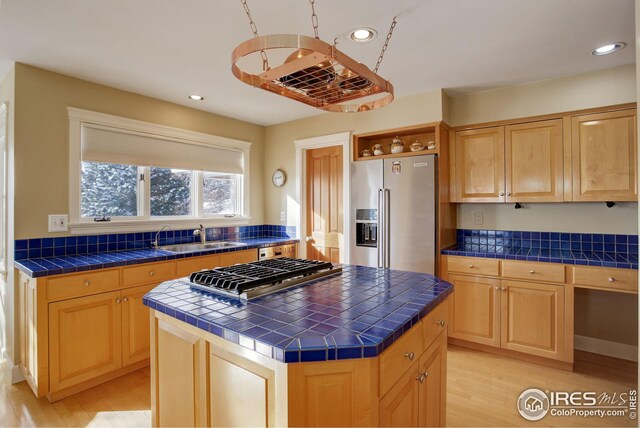 8400 Middle Fork Rd, Boulder, CO 80302 - kitchen with a center island, tile countertops, stainless steel appliances, light wood-style floors, and a sink
