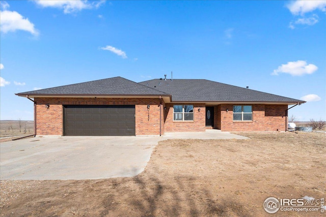 11837 County Road 39, Fort Lupton, CO 80621 - view of front of house with a garage, concrete driveway, brick siding, and a shingled roof