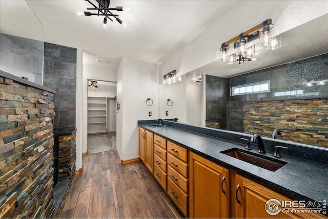 11837 County Road 39, Fort Lupton, CO 80621 - bathroom featuring wood finished floors, double vanity, a chandelier, walk in shower, and a spacious closet