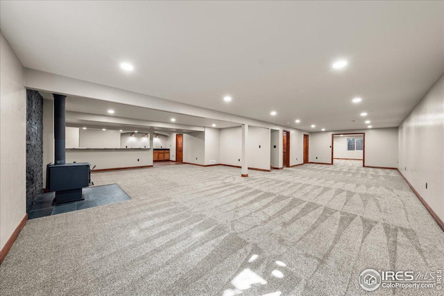 11837 County Road 39, Fort Lupton, CO 80621 - unfurnished living room featuring light carpet, a wood stove, and recessed lighting