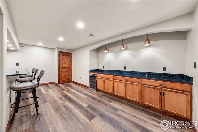 11837 County Road 39, Fort Lupton, CO 80621 - kitchen featuring beverage cooler, wood finished floors, recessed lighting, brown cabinets, and decorative light fixtures