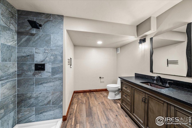 11837 County Road 39, Fort Lupton, CO 80621 - bathroom featuring wood finished floors, a tile shower, and vanity