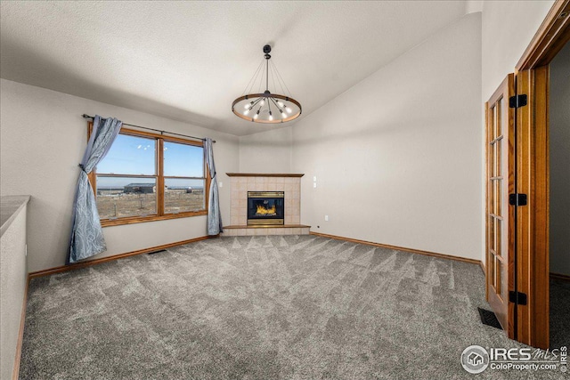 11837 County Road 39, Fort Lupton, CO 80621 - unfurnished living room featuring carpet floors, lofted ceiling, a chandelier, and a fireplace