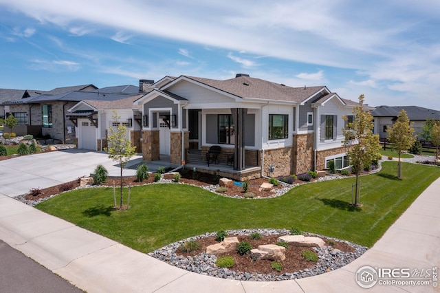 view of front facade featuring stone siding, a porch, concrete driveway, a front yard, and a garage