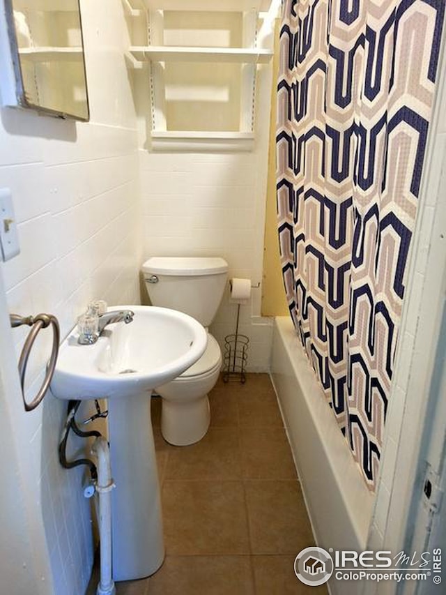 full bath with shower / bath combo with shower curtain, tile patterned flooring, and toilet