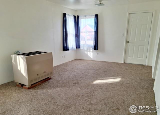 unfurnished room featuring carpet flooring and heating unit