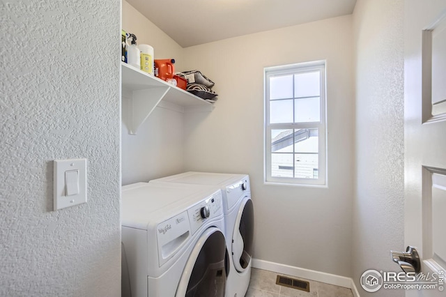 laundry room featuring laundry area, visible vents, baseboards, washer and clothes dryer, and light tile patterned flooring