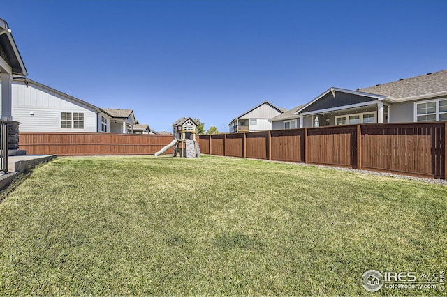 view of yard with a residential view, a playground, and a fenced backyard
