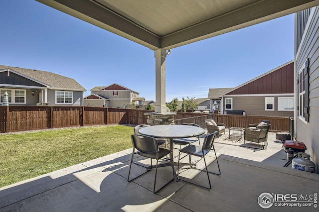 view of patio featuring outdoor dining area, fence, and a residential view