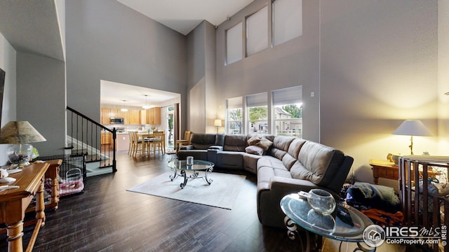 living area featuring dark wood-type flooring and stairway