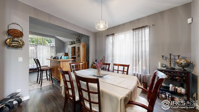 dining space featuring vaulted ceiling, dark wood-type flooring, and baseboards