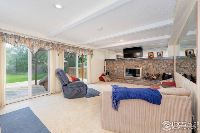 carpeted living area with a fireplace, beamed ceiling, and a textured ceiling