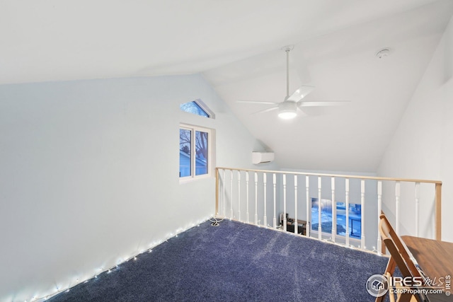 interior space with vaulted ceiling, carpet floors, a wall mounted AC, and ceiling fan