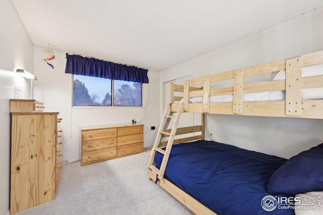 bedroom featuring light carpet and a textured ceiling