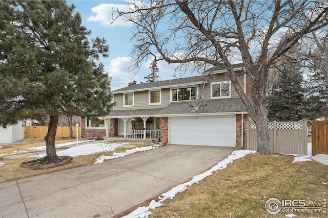 traditional-style house with concrete driveway, a porch, fence, and brick siding