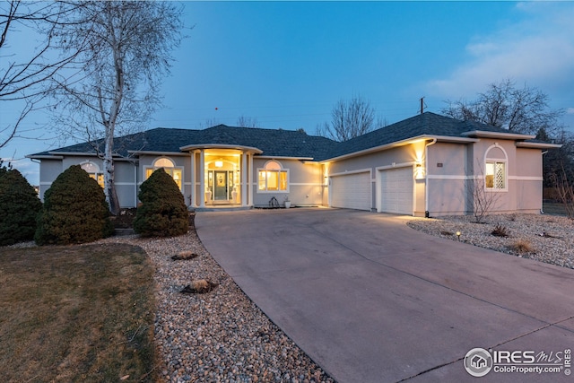ranch-style home featuring a garage, concrete driveway, a shingled roof, and stucco siding