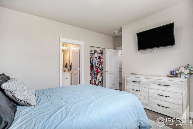 bedroom with connected bathroom and a walk in closet