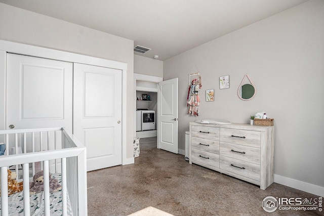 bedroom featuring finished concrete flooring, baseboards, visible vents, washer / clothes dryer, and a closet