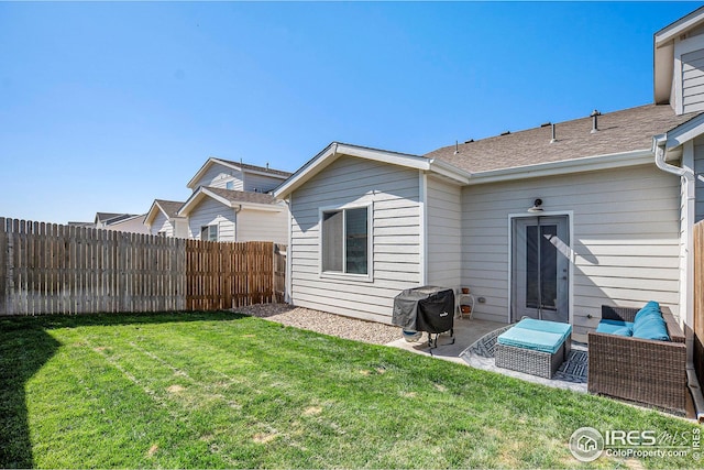 rear view of property with a fenced backyard, a patio, an outdoor living space, and a lawn