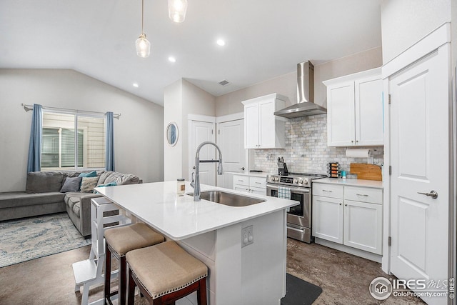 kitchen with stainless steel range oven, wall chimney exhaust hood, light countertops, and a sink