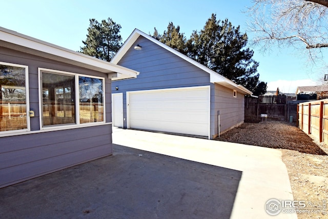 detached garage featuring fence