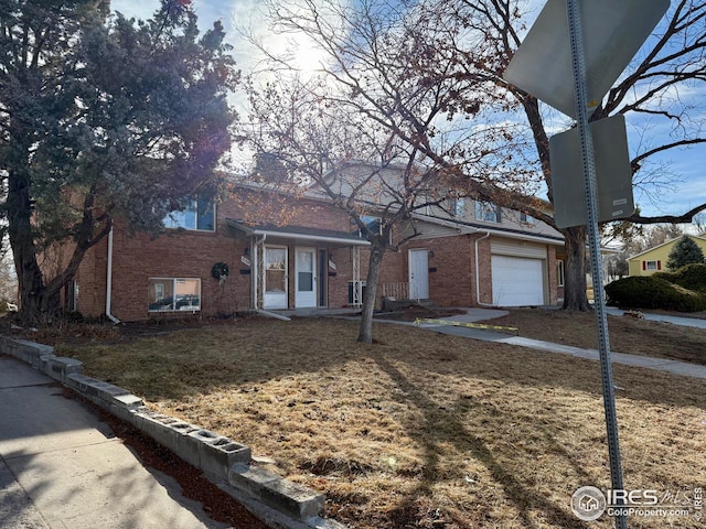 tri-level home with a front yard and brick siding