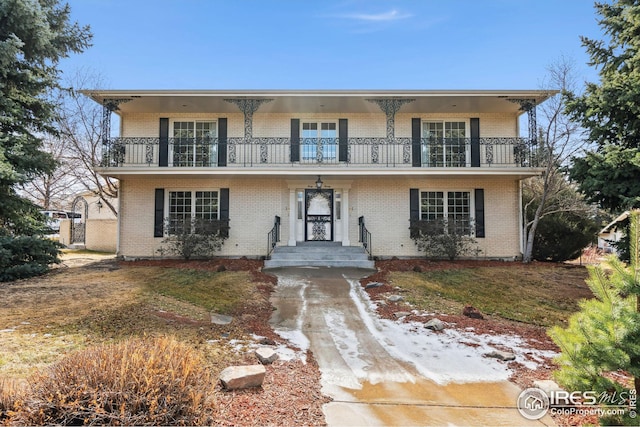 view of front property with a balcony and brick siding