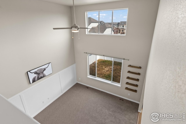carpeted spare room with ceiling fan and visible vents