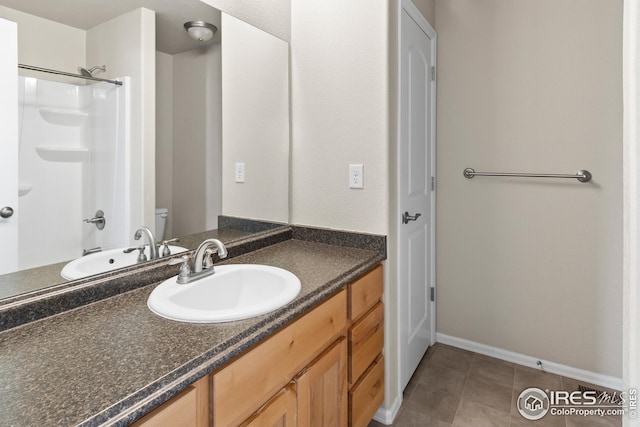 bathroom with toilet, vanity, baseboards, and tub / shower combination