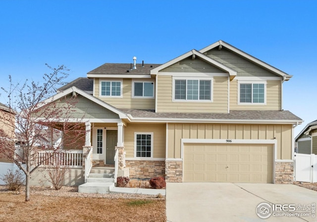 craftsman inspired home with a shingled roof, stone siding, covered porch, a garage, and driveway