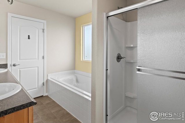 bathroom with a shower stall, vanity, and a garden tub