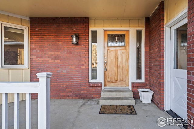 view of exterior entry featuring brick siding