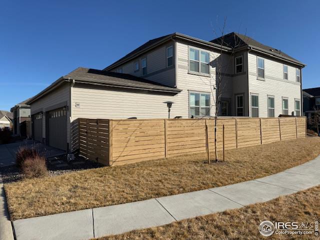 view of home's exterior with a garage and fence