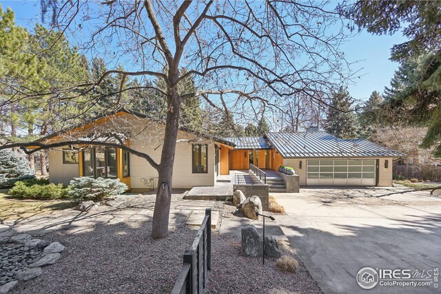 503 Kalmia Ave, Boulder, CO 80304 - view of front of home with concrete driveway, an attached garage, a standing seam roof, metal roof, and fence