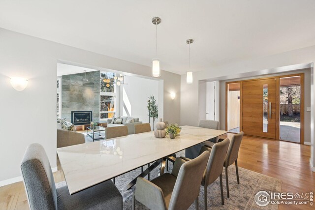 503 Kalmia Ave, Boulder, CO 80304 - dining area featuring baseboards, a fireplace, and light wood finished floors