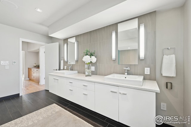 503 Kalmia Ave, Boulder, CO 80304 - bathroom featuring wood tiled floor, a sink, decorative backsplash, and double vanity