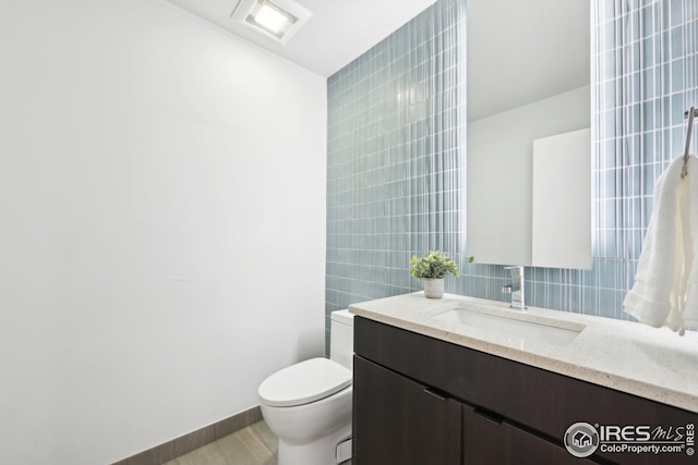 503 Kalmia Ave, Boulder, CO 80304 - half bathroom featuring visible vents, toilet, vanity, wood finished floors, and baseboards