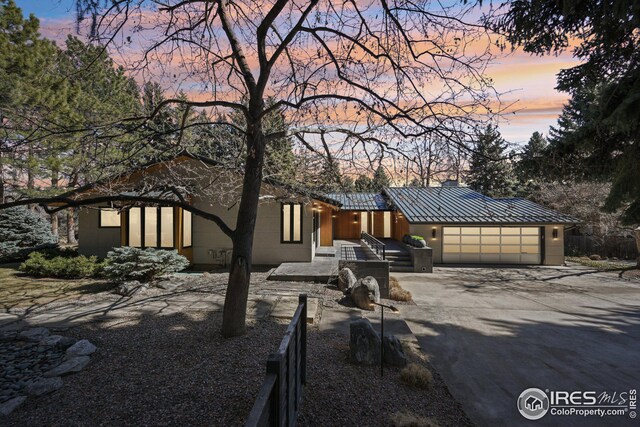 503 Kalmia Ave, Boulder, CO 80304 - view of front facade with concrete driveway, a standing seam roof, metal roof, fence, and a garage