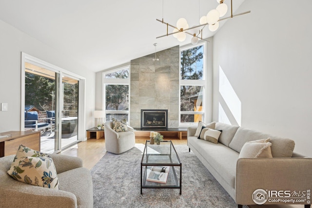 503 Kalmia Ave, Boulder, CO 80304 - living room with high vaulted ceiling, a tiled fireplace, wood finished floors, and a healthy amount of sunlight