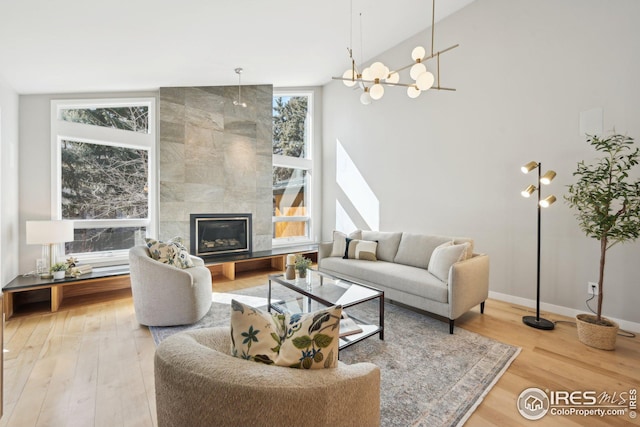 503 Kalmia Ave, Boulder, CO 80304 - living area with high vaulted ceiling, a tile fireplace, wood finished floors, and baseboards
