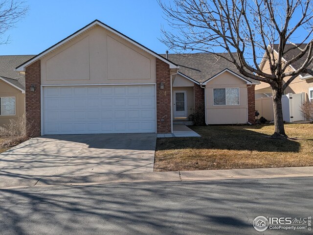 ranch-style home with brick siding, fence, driveway, and an attached garage