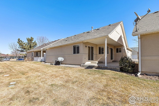 back of house with a patio area, a yard, and stucco siding